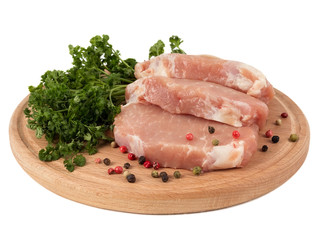 Three pieces of pork on a board with parsley and pepper