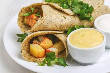 Vegetarian masala dosa with potato, chutney and sambar sauces.