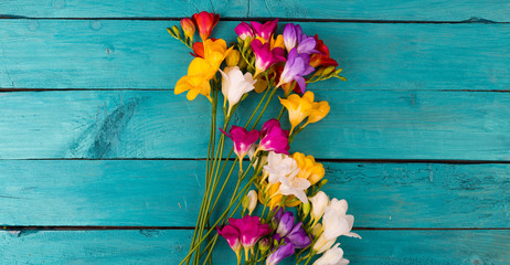 Bouquet of freesia flowers on a wooden background - obrazy, fototapety, plakaty