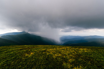 Storm rainy clouds above mountains. Apocalypse fantasy fabulous sky. Beautiful windy dramatic cloudscape at nature. Picturesque scenic view outdoor. Travel in wild territory. Discover rocky hills.