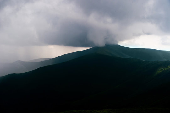 Storm rainy clouds above mountains. Apocalypse fantasy fabulous sky. Beautiful windy dramatic cloudscape at nature. Picturesque scenic view outdoor. Travel in wild territory. Discover rocky hills.