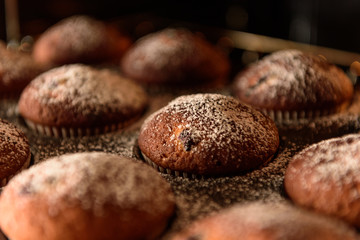 homemade muffins with forest berries on a baking tray in the oven