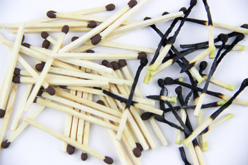 A bunch of burnt and whole matches on a white background