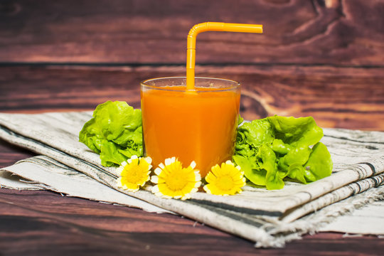 Healthy carrot smoothie in a glass, on a rustic white wood background