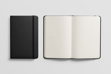 Photorealistic black leather notebook mockup on light grey background. Front and opened view.