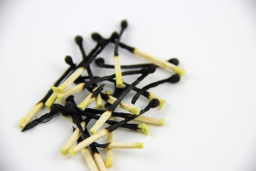 A bunch of burnt and whole matches on a white background