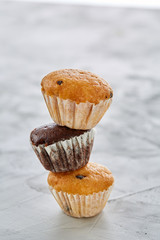 Tasty muffins arranged in pattern on light textured background, close-up, shallow depth of field, selective focus.