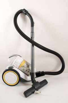 Yellow-colored vacuum cleaner with a brush sucks US dollars. Concept to succeed in business. White background