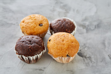 Tasty muffins arranged in pattern on light textured background, close-up, shallow depth of field, selective focus.