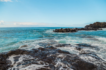 The blue waters of the Atlantic Ocean flowing into rocky cove off the coast of Tenerife.  rocky shores of Canary Islands.