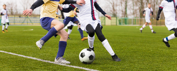 Junior football match. Boys Boys playing soccer match on professional football pitch. Football Stadium in the Background