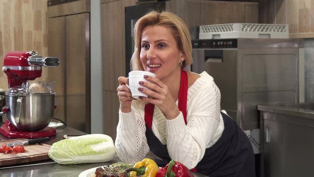 Happy Gorgeous Mature Housewife Smiling Joyfully To The Camera Enjoying Drinking Coffee At Home After Cooking At The Kitchen Femininity Maturity Lifestyle Vitality Happiness Living.