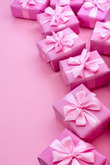 Decorative holiday gift boxes with pink color on pink background.