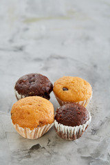 Tasty muffins arranged in pattern on light textured background, close-up, shallow depth of field, selective focus.