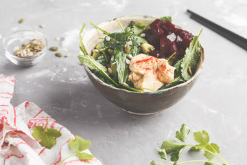 Green vegan salad with kale, beetroot, cucumber, sunflower seeds with hummus dressing, copy space. Healthy vegetarian detox food concept.