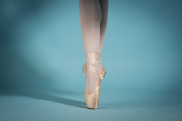 feet of the ballerina in toe shoes on the turquoise background