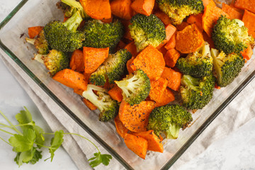 Baked broccoli and sweet potato with spices in a glass dish, top view. Vegan Healthy Food Concept.