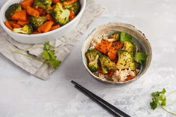 Brown rice with baked broccoli and sweet potato on white background. Healthy vegan food concept.