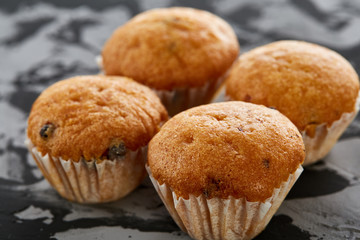 Tasty muffins arranged in pattern on light textured background, close-up, shallow depth of field, selective focus.