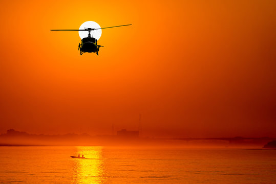 silhouette of helicopter with sunset.
