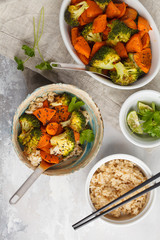 Brown rice with baked broccoli and sweet potato on white background, top view. Healthy vegan food concept.