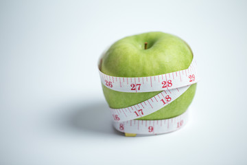 fresh apple with measuring tape. isolated over white background