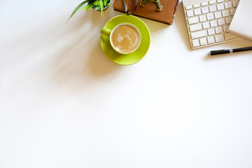 White office desk table with computer, cup of coffee and supplies. Top view with copy space, flat lay.
