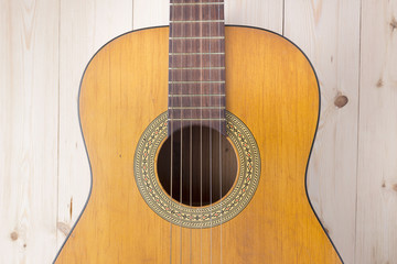 Fototapeta premium Acoustic guitar on a wooden background top view