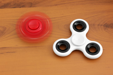 Red and white spinners. Toys. Two spinners on a wooden background. 