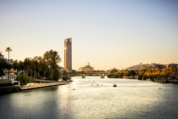 View of Seville Tower (Torre Sevilla) of Seville, Andalusia, Spain over river Guadalquivir at sunset