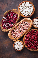 Assortment of various beans in wooden bowls 