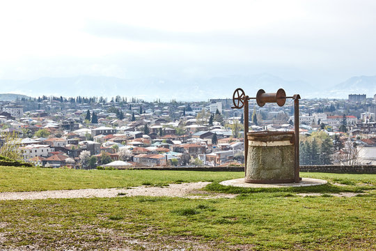 Retro old well on the background of the city panorama. Kutaisi, Georgia.