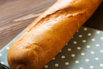 Fresh baguette on the kitchen table. Close-up. Traditional baguette for breakfast.