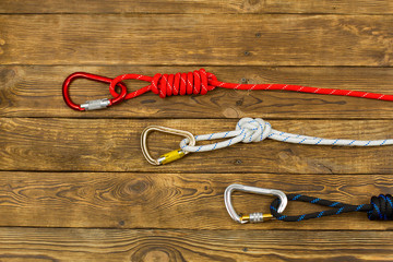 Carabiners on a wooden background. Climbing equipment.