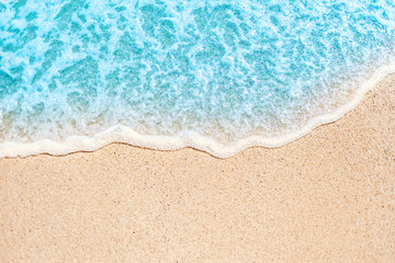 Fototapeta na wymiar Soft wave of blue ocean on sandy beach with copy space fr text. Summer Background.