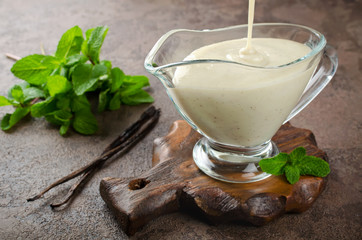Vanilla sauce with fresh mint branches on a dark background