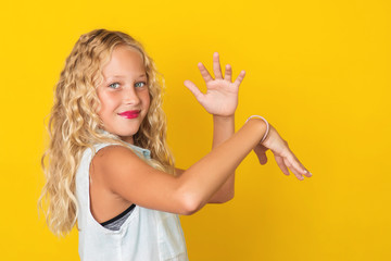 Handsome young girl posing on yellow background.