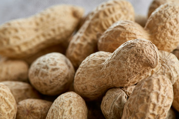 Heap of peanuts on light tablecloth, close-up, shallow depth of field, selective focus, macro