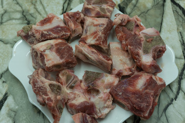 Raw beef meat with butcher knife on slate plate.Scattered black pepper, chili .Dark bakcground.Selective focus .