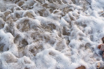 Gravel on the sea-shore and sea foam