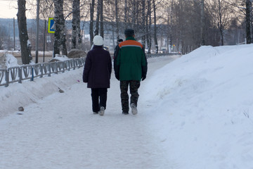 Photo of elderly couple walking in the park .