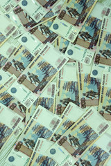 Obraz premium A pack of five rouble banknotes in half a million Russian rubles in a Bank package is on the background of disparate banknotes .