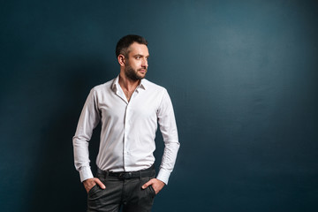 Handsome serious man standing over dark blue background