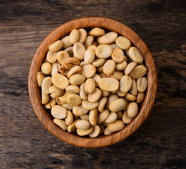 Raw coffee beans in wood bowl