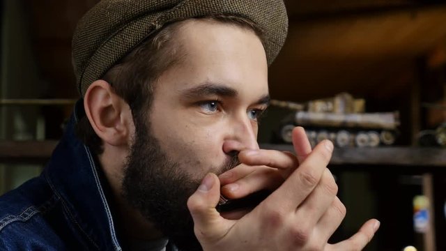 Musician plays the harmonica. Young men enjoying music by harmonica. Close-up portrait of expressive young man playing harmonica.
