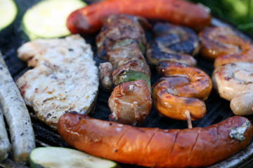 A set of meats baked on the grill during a family picnic in free time. Summer relaxation in the open air.