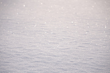 Natural background - ice surface of snow illuminated by the rays of the evening sun. The sun's rays bouncing off the gleaming crystals loose ice.