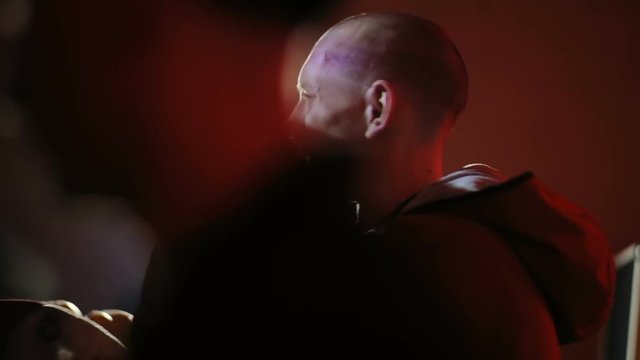 Side view of emotional young man singing rap music in the night club / expression emotions face cool guy gesturing cap hipster mc microphone concert light flare hiphop