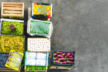 Top view of boxes with vegetables and fruit on asphalt