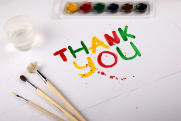 inscription on white sheet of paper with watercolors Thank you 